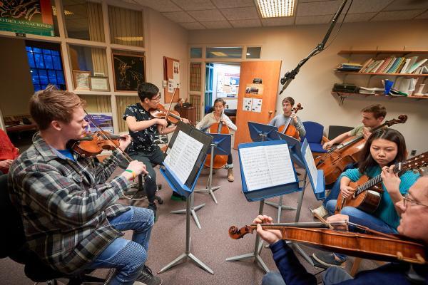 Students play instruments in a classroom